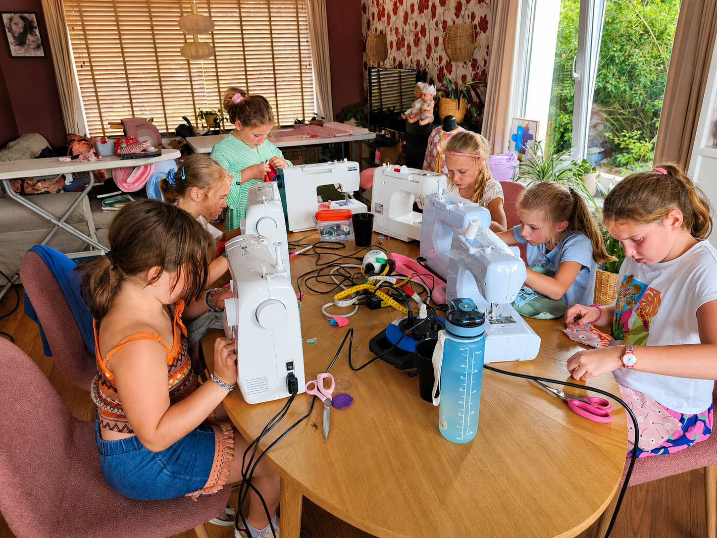 Kinderen werken samen aan hun naaiprojecten tijdens het naaikamp van Atelier KVG in Essen