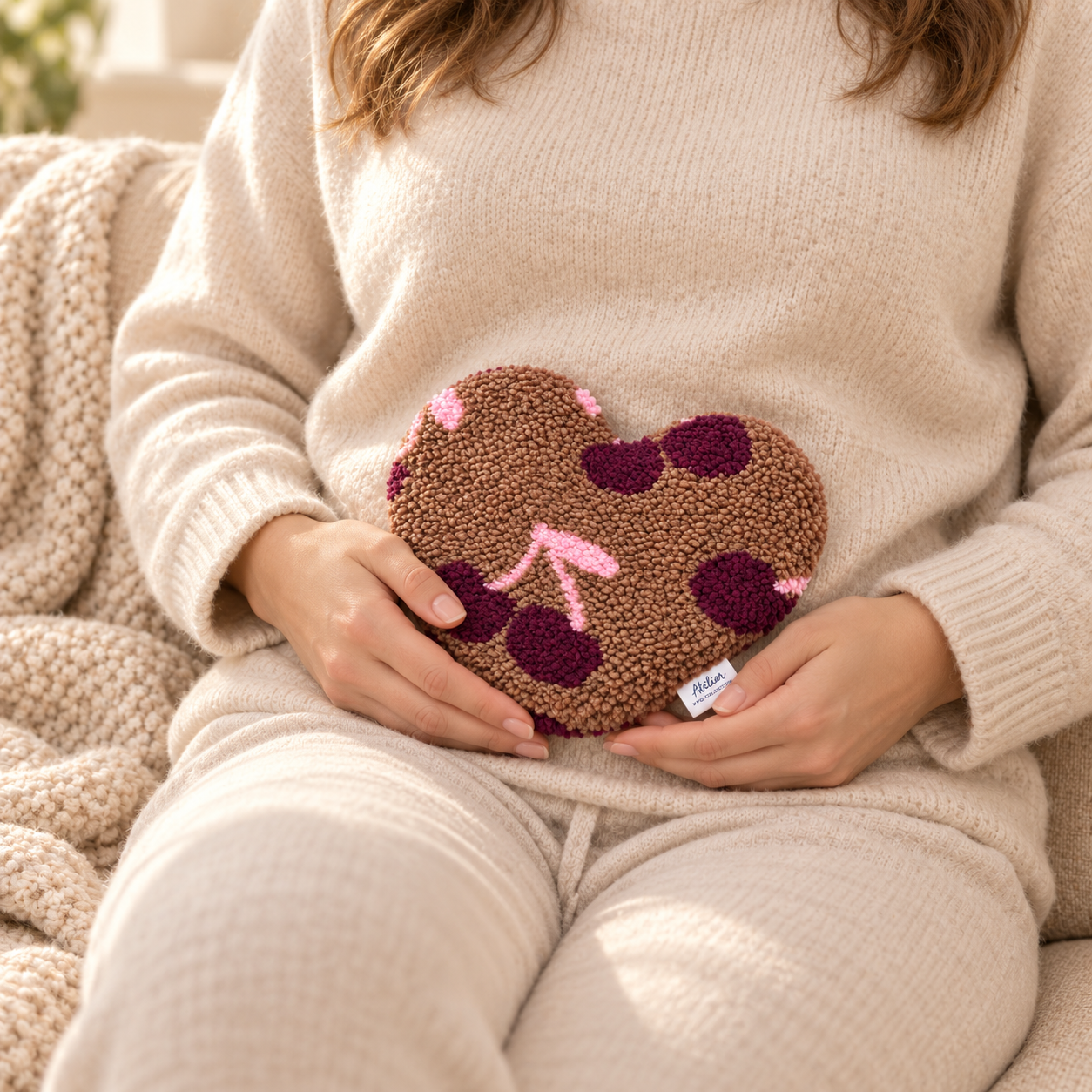 Hartvormig teddy kersenpitkussen gebruikt als warmtekussen tegen de buik