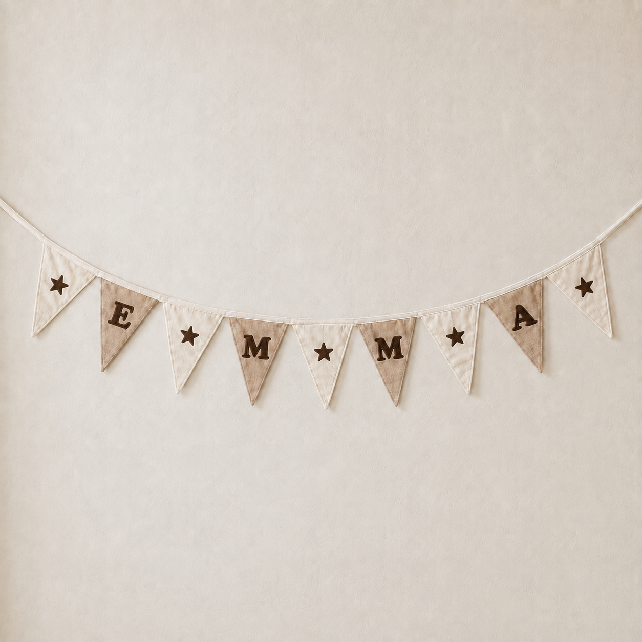 Atelier KVG – gepersonaliseerde DIY-vlaggenlijn in gebroken wit en taupe met naam EMMA en donkerbruine flocksterretjes