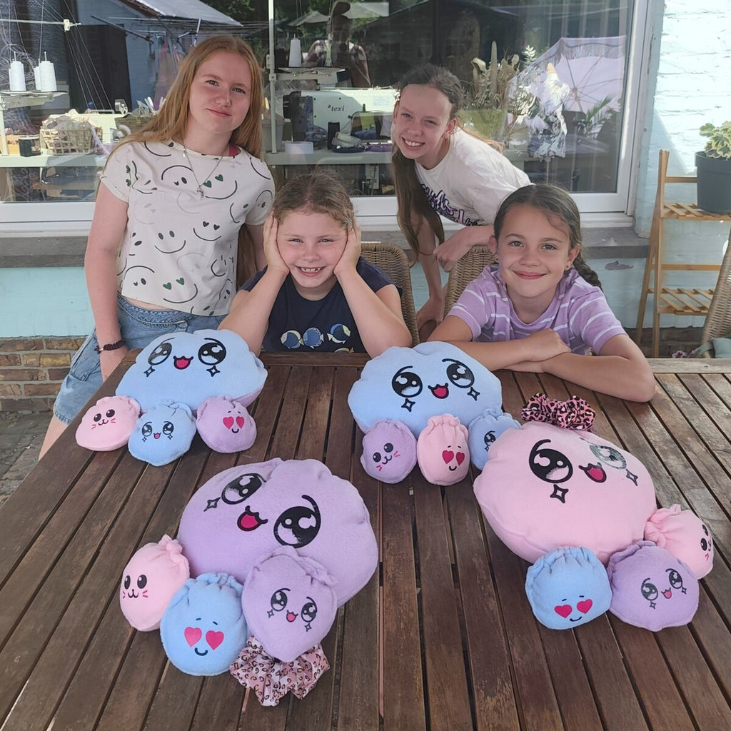 Kinderen tonen hun zelfgemaakte dumplings tijdens een naaiworkshop bij Atelier KVG in Essen