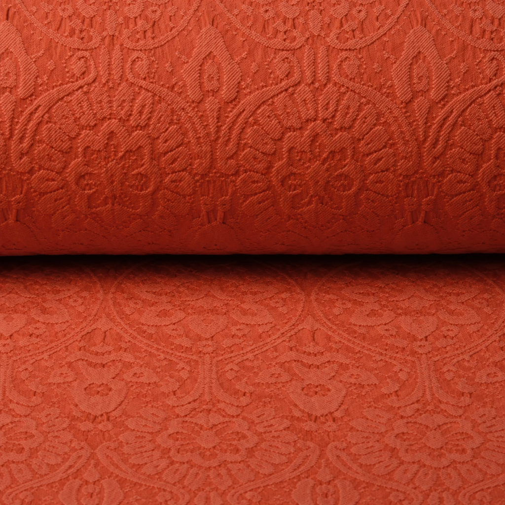 Oranje jacquard Charissa op rol met glanzend ingeweven motief
