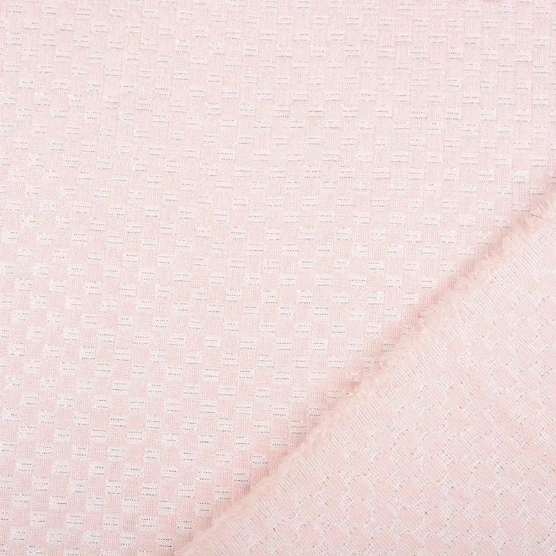 Detail van pastelroze jacquard met lurex en subtiel geometrisch reliëf