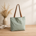 Voorbeeld van een gevoerde tote bag met groene katoen en bruine handvatten, te maken tijdens een begeleide naailes.