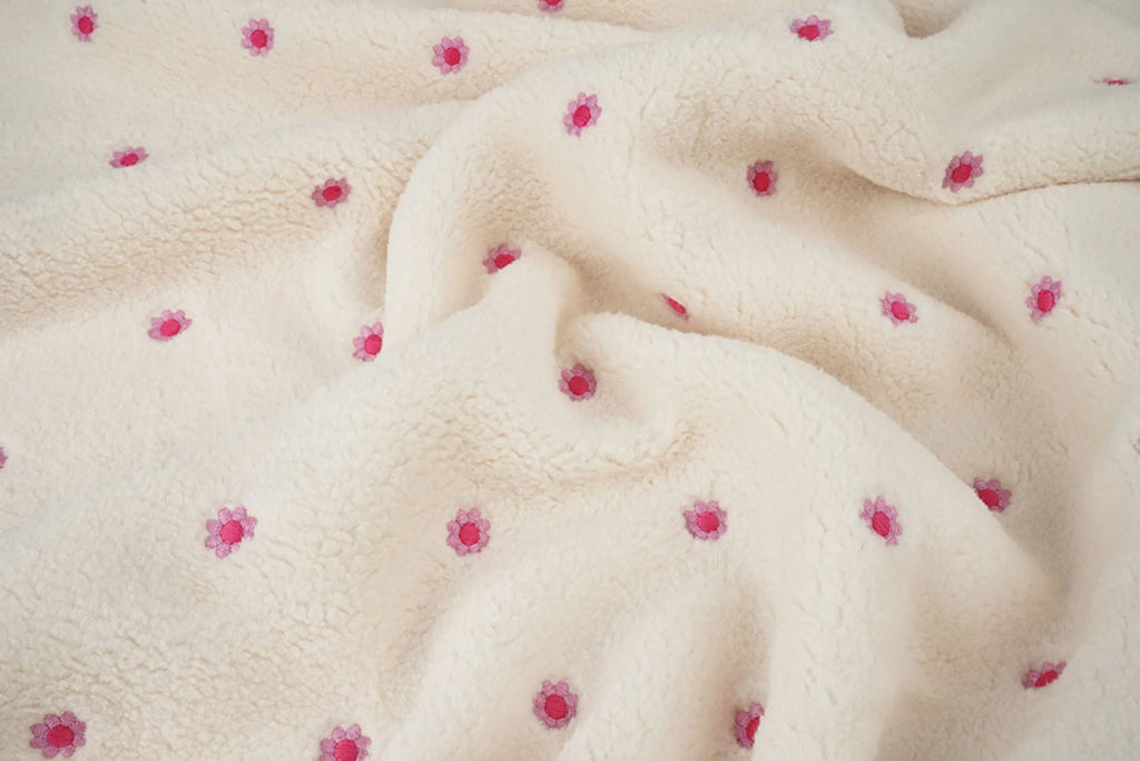 Crèmekleurige teddy fleece met kleine geborduurde roze bloemen