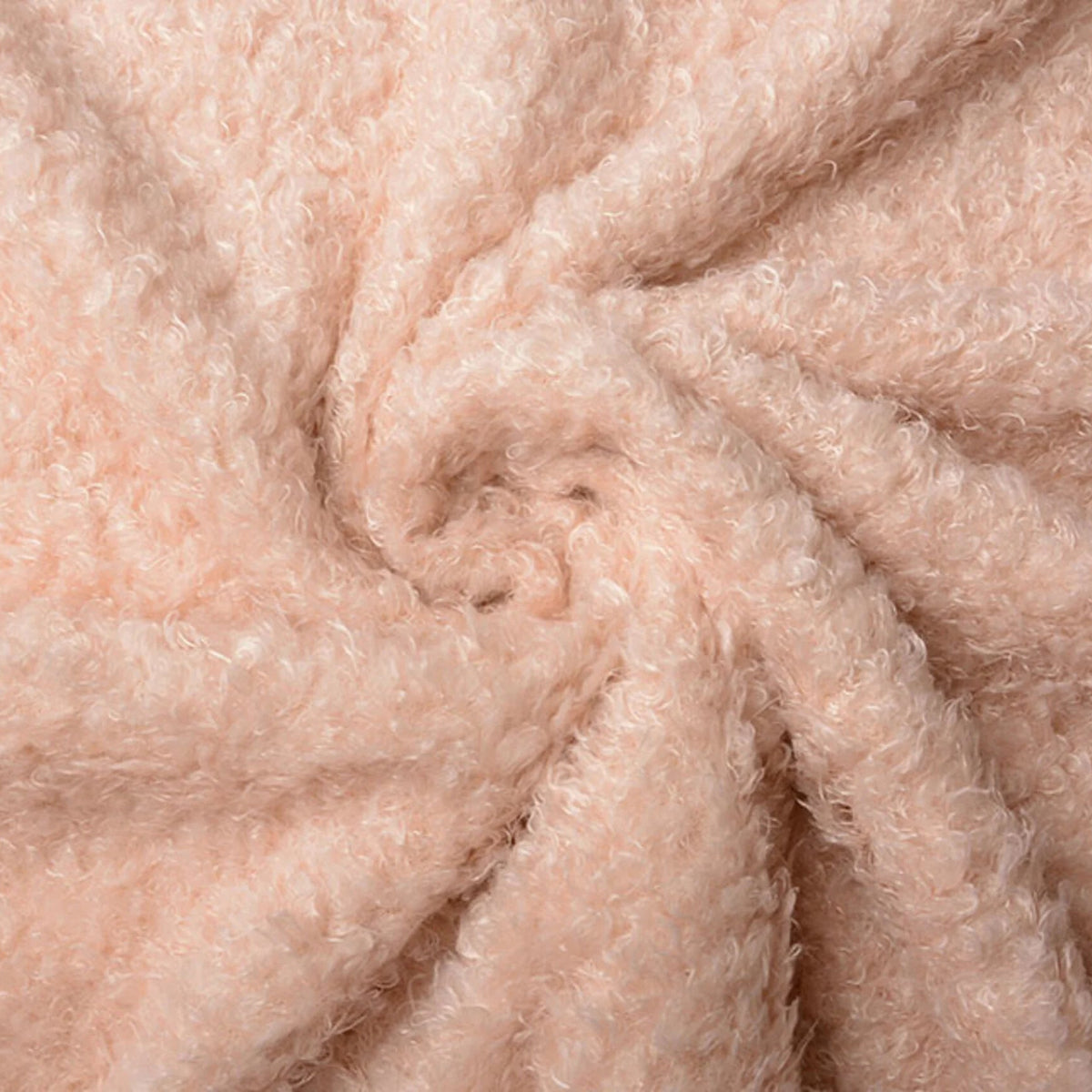 Detail van de zachte krulstructuur van Wavy Curly teddy stof in peach